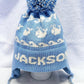 EARFLAP HAT WITH DESIGN AND POMPOM